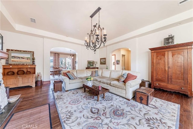 26525 Carancho Rd, Temecula, CA 92590 - living area featuring arched walkways, a chandelier, dark wood-style floors, and a tray ceiling