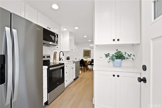 17805 Winterberry St, Fountain Valley, CA 92708 - kitchen featuring stainless steel appliances, white cabinetry, light wood-type flooring, a sink, and recessed lighting