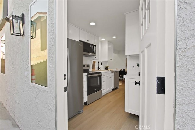 17805 Winterberry St, Fountain Valley, CA 92708 - kitchen with stainless steel appliances, white cabinetry, light wood-type flooring, recessed lighting, and a sink