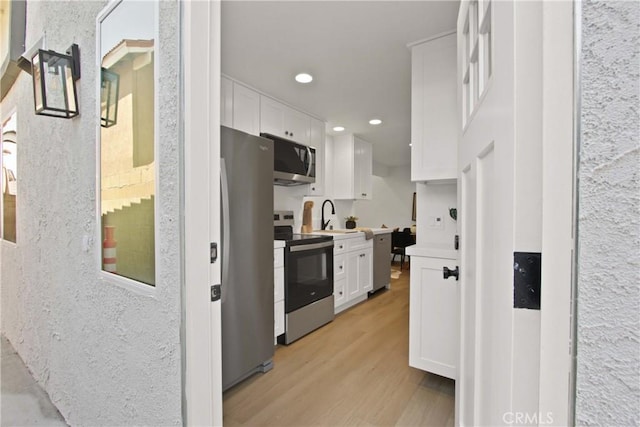 17805 Winterberry St, Fountain Valley, CA 92708 - kitchen featuring appliances with stainless steel finishes, white cabinets, light wood-type flooring, recessed lighting, and light countertops