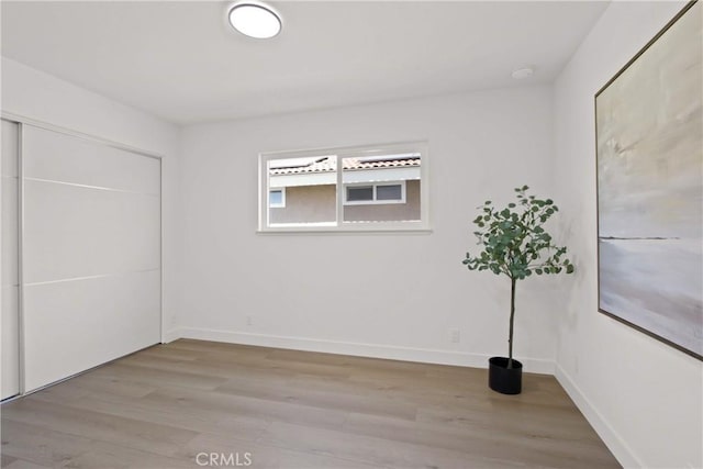17805 Winterberry St, Fountain Valley, CA 92708 - unfurnished bedroom with light wood-type flooring, baseboards, and a closet