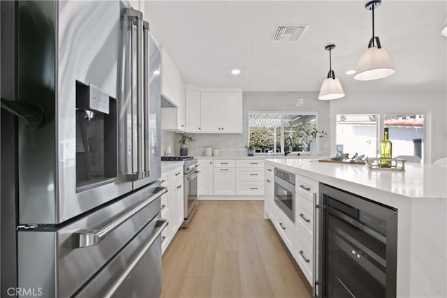 17805 Winterberry St, Fountain Valley, CA 92708 - kitchen with stainless steel appliances, wine cooler, light countertops, recessed lighting, and white cabinetry