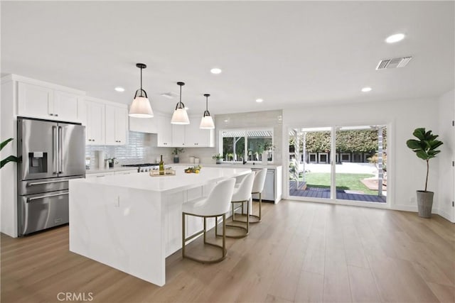 17805 Winterberry St, Fountain Valley, CA 92708 - kitchen with appliances with stainless steel finishes, a kitchen island, light countertops, white cabinets, and recessed lighting