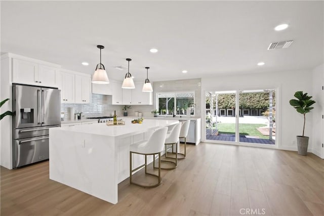 17805 Winterberry St, Fountain Valley, CA 92708 - kitchen with high end refrigerator, a kitchen island, light countertops, white cabinets, and recessed lighting