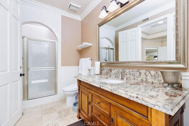 30801 Via Conquista, San Juan Capistrano, CA 92675 - bathroom featuring toilet, vanity, a stall shower, crown molding, and a wainscoted wall