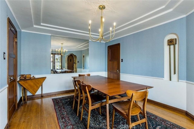 209 Ximeno Ave, Long Beach, CA 90803 - dining room featuring a chandelier, a raised ceiling, wood finished floors, ornamental molding, and arched walkways