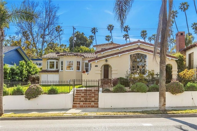 209 Ximeno Ave, Long Beach, CA 90803 - mediterranean / spanish house featuring a tile roof, stucco siding, a fenced front yard, and a gate