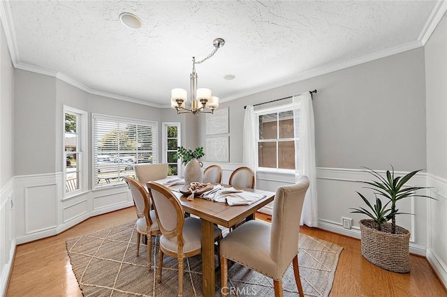 435 Orlena Ave, Long Beach, CA 90814 - dining room with a chandelier, a textured ceiling, light wood-style flooring, wainscoting, and crown molding
