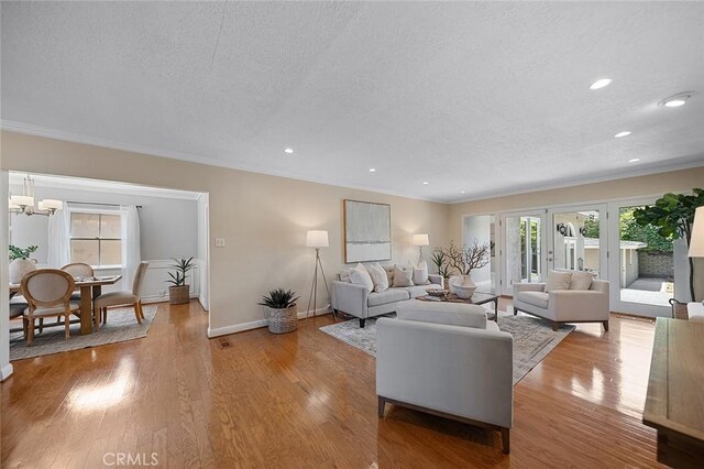 435 Orlena Ave, Long Beach, CA 90814 - living area featuring a textured ceiling, healthy amount of natural light, a chandelier, baseboards, and light wood-type flooring