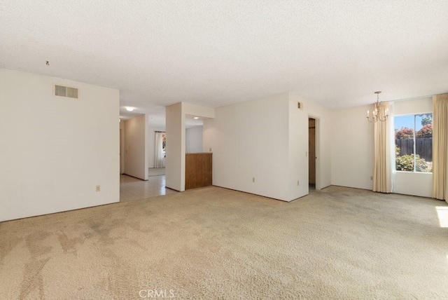 2740 Whitney St, San Diego, CA 92111 - empty room with light carpet, a chandelier, and a textured ceiling