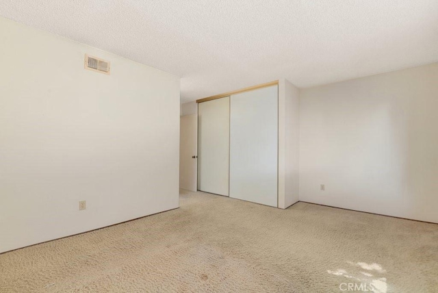 2740 Whitney St, San Diego, CA 92111 - unfurnished bedroom with carpet, a closet, and a textured ceiling