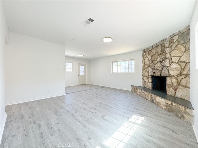 1710 W Arbutus St, Compton, CA 90220 - unfurnished living room featuring light wood finished floors, healthy amount of natural light, and a stone fireplace