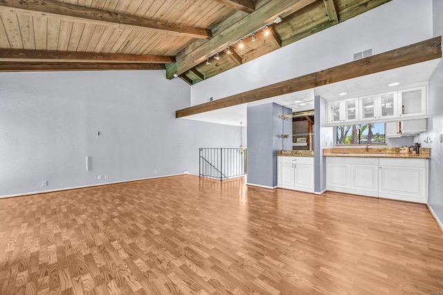 1905 Alga Rd Unit C, Carlsbad, CA 92009 - unfurnished living room featuring light wood-type flooring, wooden ceiling with exposed beams, a sink, track lighting, and baseboards