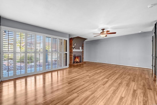 1905 Alga Rd Unit C, Carlsbad, CA 92009 - unfurnished living room featuring ceiling fan, baseboards, light wood finished floors, and a brick fireplace
