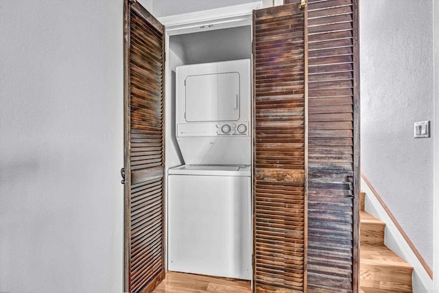 1905 Alga Rd Unit C, Carlsbad, CA 92009 - laundry area featuring estacked washer and dryer, a textured wall, and wood finished floors