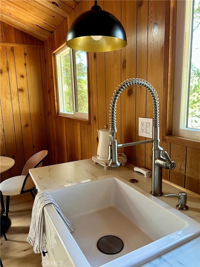 2484 Pine Dr, Running Springs, CA 92382 - kitchen view of a sink, wood walls, brown cabinetry, and light countertops