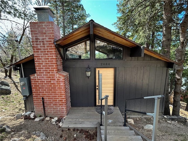 2484 Pine Dr, Running Springs, CA 92382 - view of exterior entry featuring a chimney