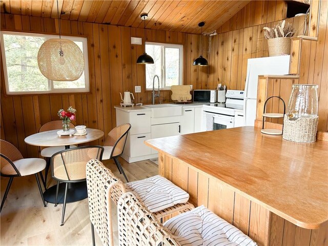 2484 Pine Dr, Running Springs, CA 92382 - kitchen with a sink, white appliances, light wood-type flooring, wooden walls, and wood ceiling