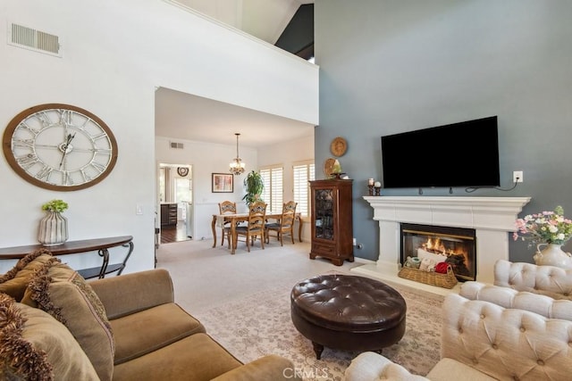 43650 Buckeye Rd, Temecula, CA 92592 - carpeted living area featuring a chandelier, a high ceiling, and a glass covered fireplace