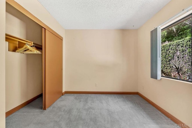 368 Travelodge Dr, El Cajon, CA 92020 - unfurnished bedroom with light colored carpet, a textured ceiling, a closet, and baseboards