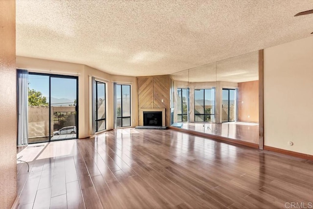 368 Travelodge Dr, El Cajon, CA 92020 - unfurnished living room with a textured ceiling, healthy amount of natural light, wood finished floors, and a fireplace with raised hearth
