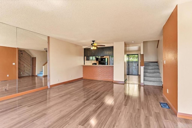 368 Travelodge Dr, El Cajon, CA 92020 - unfurnished living room with stairs, a textured ceiling, ceiling fan, wood finished floors, and baseboards