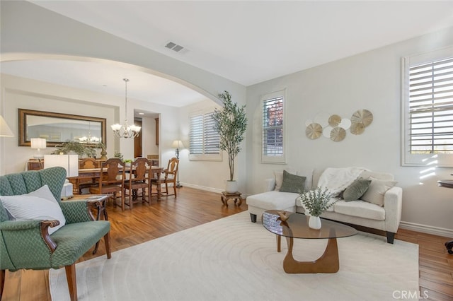 24923 Hearth Ct, Valencia, CA 91354 - living area featuring arched walkways, wood finished floors, baseboards, and a chandelier