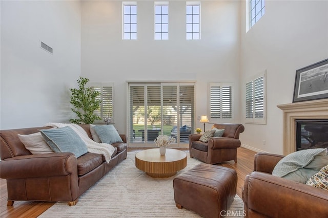 24923 Hearth Ct, Valencia, CA 91354 - living area with a towering ceiling, wood finished floors, baseboards, and a glass covered fireplace