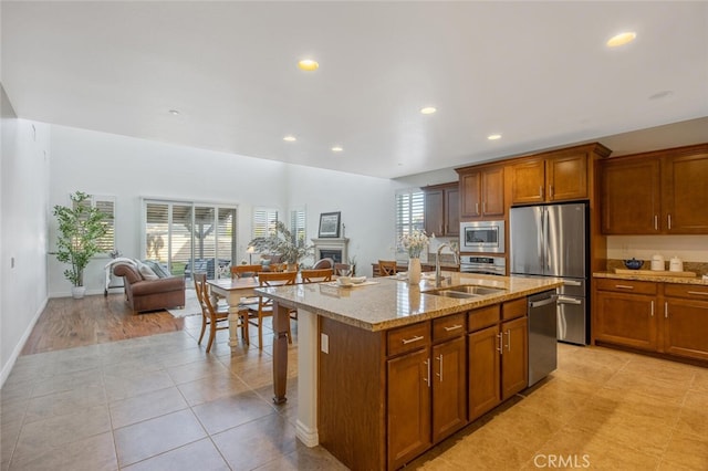 24923 Hearth Ct, Valencia, CA 91354 - kitchen with stainless steel appliances, open floor plan, light stone countertops, recessed lighting, and brown cabinets