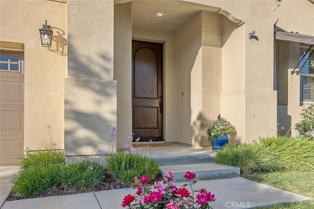 24923 Hearth Ct, Valencia, CA 91354 - view of exterior entry with stucco siding and a garage