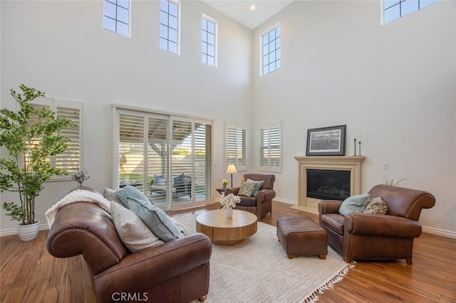 24923 Hearth Ct, Valencia, CA 91354 - living area with a towering ceiling, wood finished floors, baseboards, and a fireplace with flush hearth