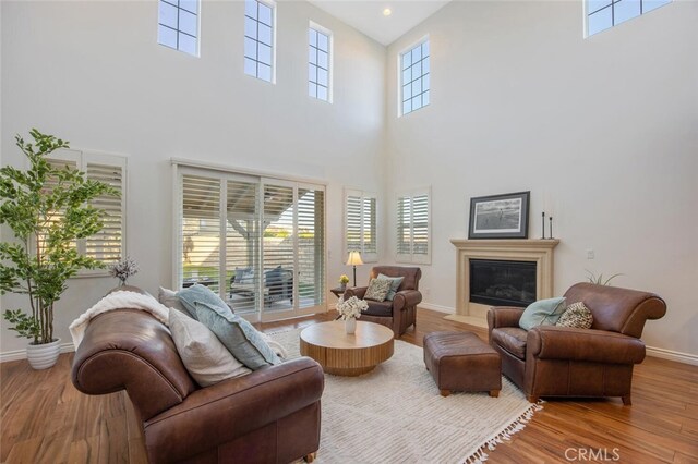 24923 Hearth Ct, Valencia, CA 91354 - living area featuring a towering ceiling, wood finished floors, and a glass covered fireplace