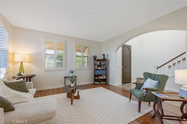 24923 Hearth Ct, Valencia, CA 91354 - living area featuring arched walkways, wood finished floors, stairs, and baseboards
