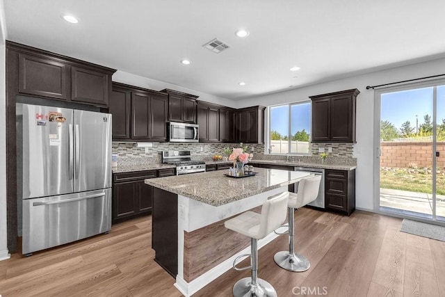 30536 Astoria Ln, Murrieta, CA 92563 - kitchen featuring stainless steel appliances, dark brown cabinets, light stone counters, backsplash, and recessed lighting