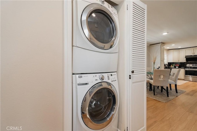 3438 Bahia Blanca W Unit B, Laguna Woods, CA 92637 - washroom featuring stacked washer and clothes dryer, light wood-type flooring, and recessed lighting