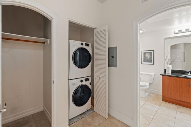 1225 Island Ave Unit 503, San Diego, CA 92101 - laundry area with stacked washer / drying machine, electric panel, light tile patterned flooring, and baseboards