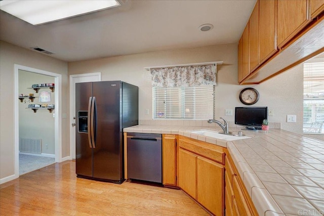 221 E Old Julian Hwy, Ramona, CA 92065 - kitchen with stainless steel appliances, a sink, tile counters, light wood-style floors, and brown cabinets