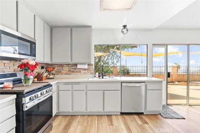 12518 Bernadette St, Pacoima, CA 91331 - kitchen featuring stainless steel appliances, a sink, light wood-type flooring, and light countertops