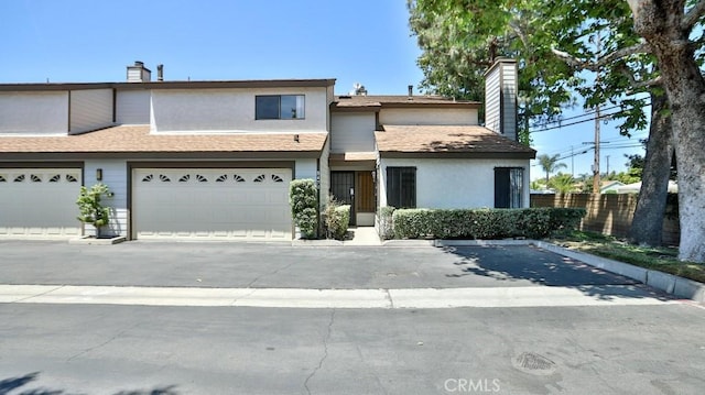 8471 Evergreen, Garden Grove, CA 92841 - view of property featuring a chimney, a shingled roof, stucco siding, and a garage