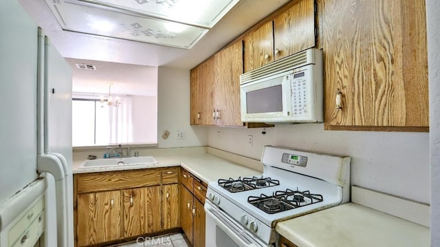 8471 Evergreen, Garden Grove, CA 92841 - kitchen with white appliances, brown cabinetry, a chandelier, and light countertops