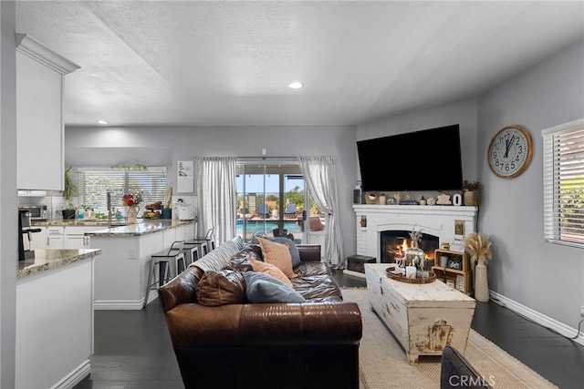 22565 Pecan Pl, Saugus, CA 91390 - living area with a glass covered fireplace, baseboards, recessed lighting, wood finished floors, and a textured ceiling