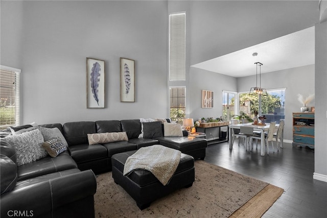22565 Pecan Pl, Saugus, CA 91390 - living room with a towering ceiling, dark wood-type flooring, baseboards, and a chandelier