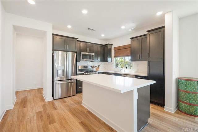 4366 Pacifica Way Unit 5, Oceanside, CA 92056 - kitchen featuring stainless steel appliances, a sink, a center island, dark brown cabinetry, and light wood-style floors
