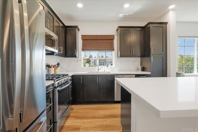 4366 Pacifica Way Unit 5, Oceanside, CA 92056 - kitchen with stainless steel appliances, a sink, light wood finished floors, recessed lighting, and tasteful backsplash