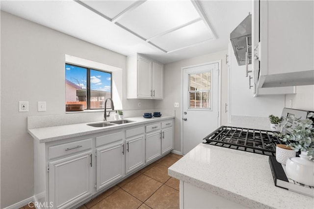 38115 41st St E, Palmdale, CA 93552 - kitchen with a sink, extractor fan, light tile patterned flooring, white cabinetry, and baseboards