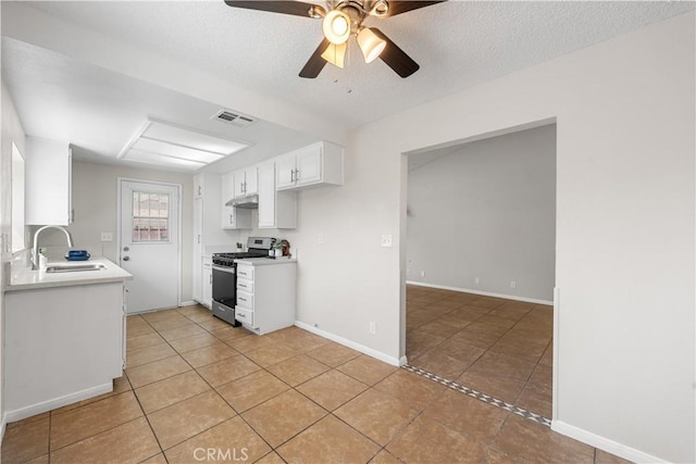 38115 41st St E, Palmdale, CA 93552 - kitchen with stainless steel gas range oven, a sink, light tile patterned floors, under cabinet range hood, and light countertops