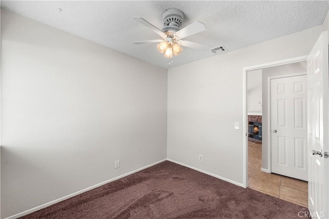 38115 41st St E, Palmdale, CA 93552 - carpeted spare room featuring a ceiling fan, a brick fireplace, a textured ceiling, baseboards, and tile patterned flooring