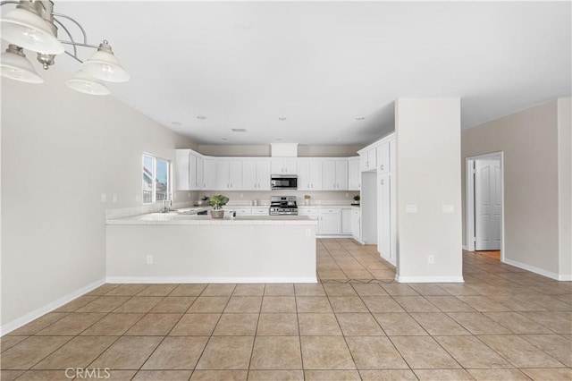 43453 Tali St, Lancaster, CA 93535 - kitchen featuring appliances with stainless steel finishes, a peninsula, light tile patterned flooring, white cabinets, and a sink