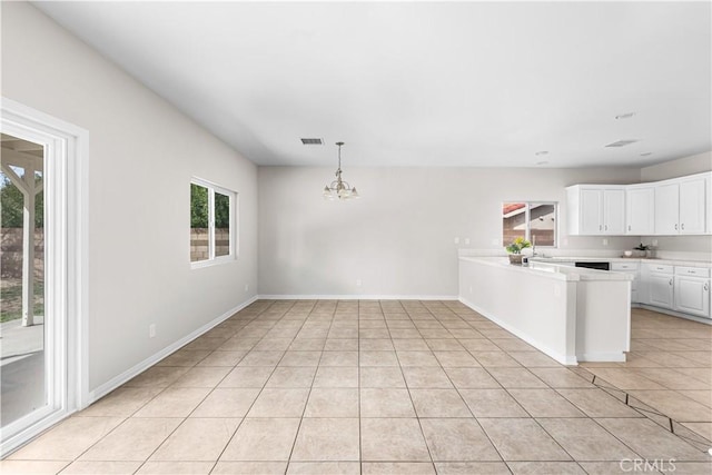 43453 Tali St, Lancaster, CA 93535 - kitchen with light tile patterned floors, a chandelier, light countertops, white cabinetry, and a peninsula