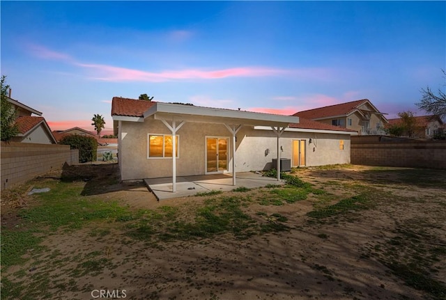 43453 Tali St, Lancaster, CA 93535 - back of property at dusk featuring a patio area, stucco siding, and central AC